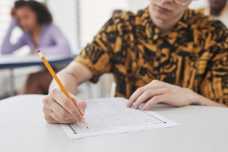 Student filling out an AP exam answer sheet in a classroom