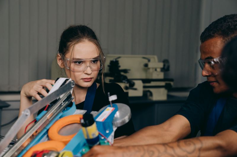 Student in safety glasses working in a lab without a prior engineering background