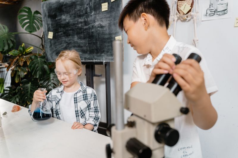 High school student working at a microscope during a summer biomedical research program