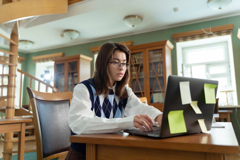 Student writing a Brown pre-college program application essay on a laptop