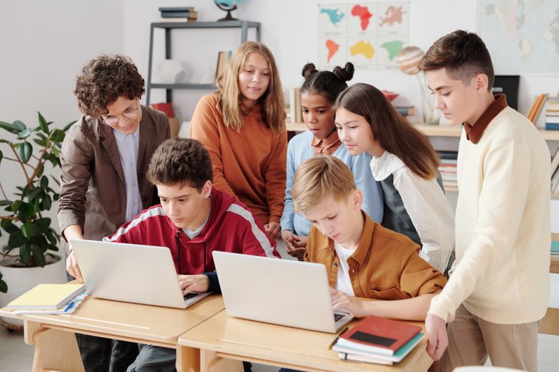 Students collaborating on laptops during a business internship program