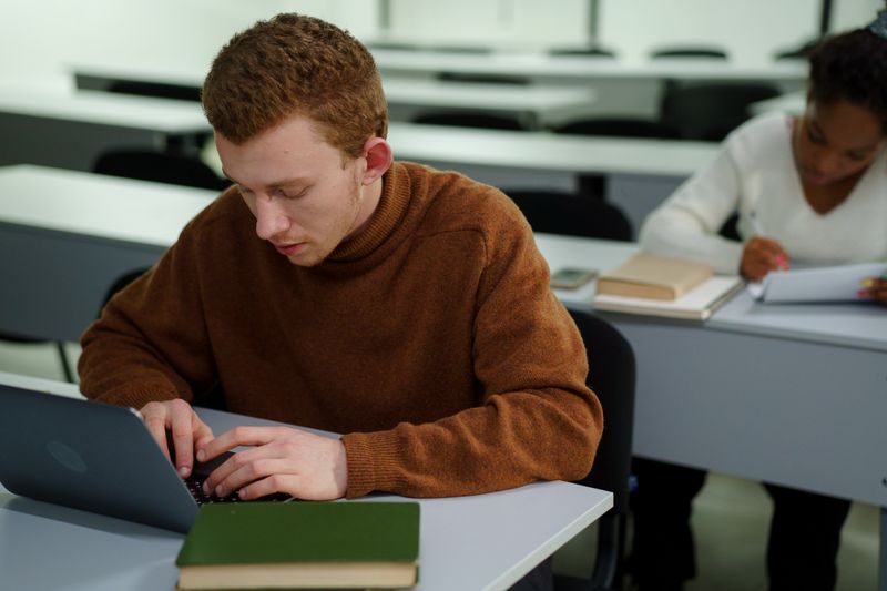 Student typing a cold email subject line on a laptop