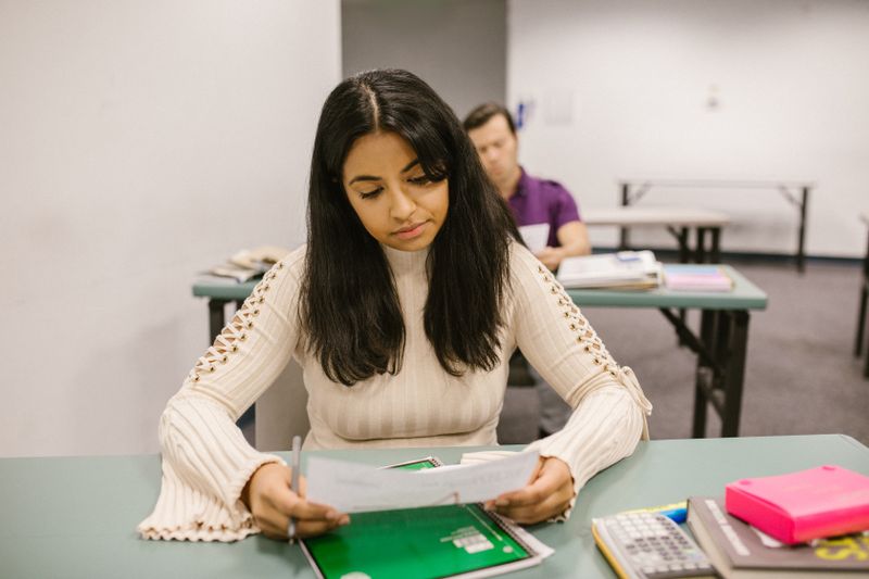 Student reviewing application documents carefully at a desk