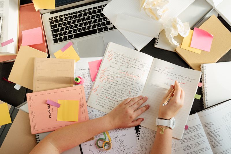 Cluttered desk with scattered notes representing common college application spreadsheet mistakes