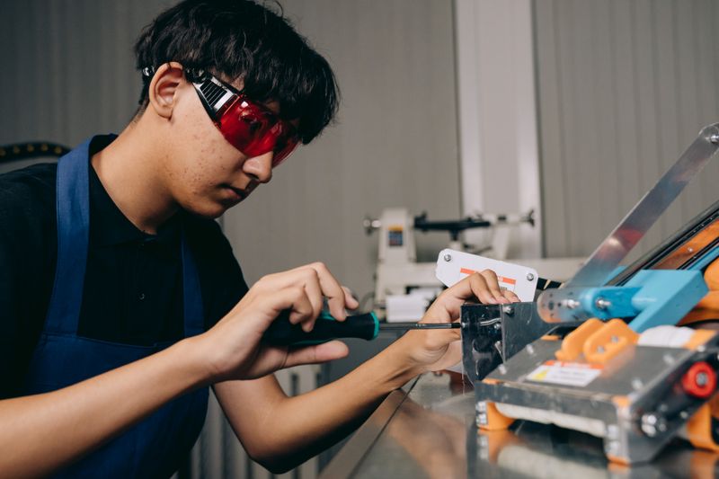Student wearing safety glasses building a prototype for a Conrad Challenge category