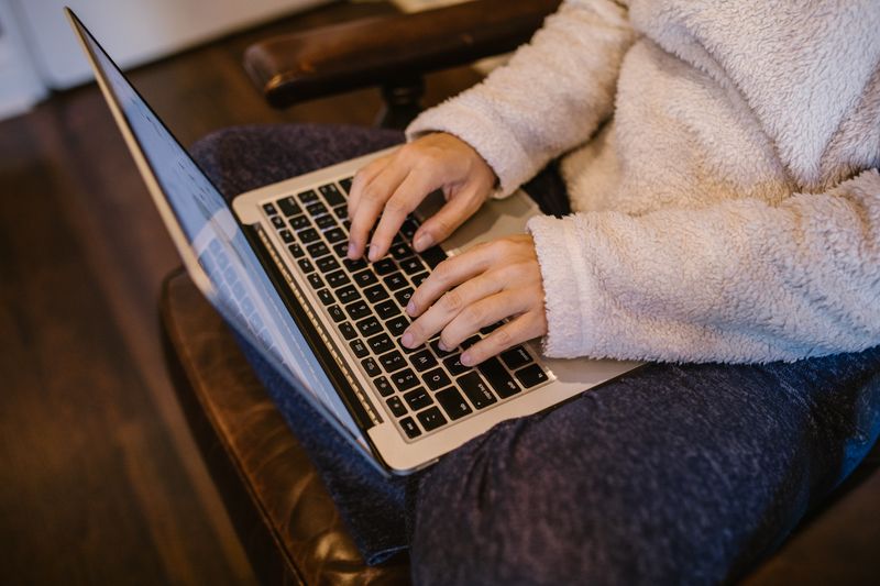 Hands typing on a laptop while researching pre-college program cost