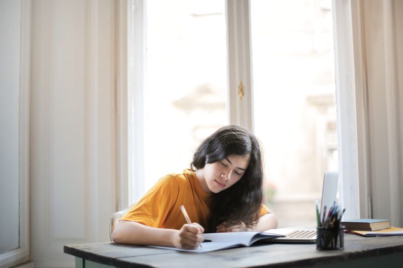 High school student writing a personal statement for a competitive cosmos summer program application
