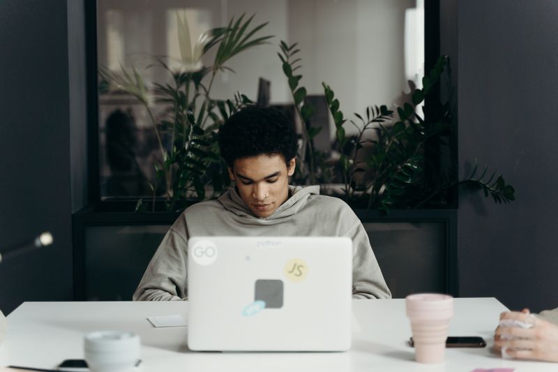 Student focused deeply on laptop work representing depth over breadth in college applications