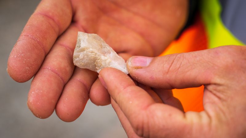 Hands examining a mineral sample, practice for the earth science olympiad practical exam
