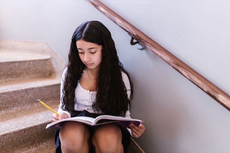 High school student writing research notes independently — free research opportunities available