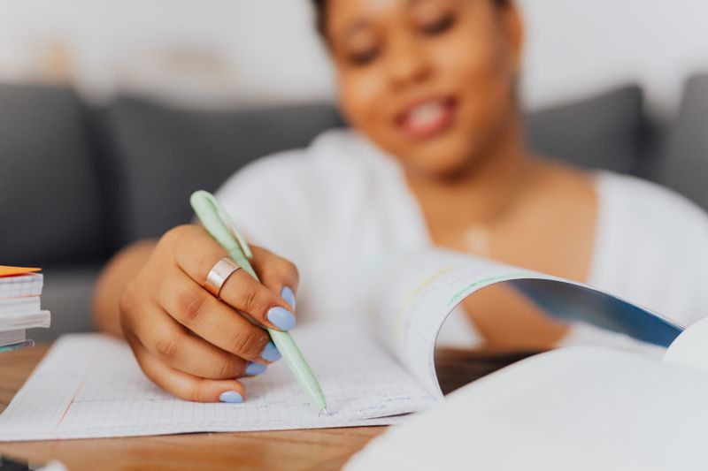 High school student taking notes and preparing to write a research outreach email