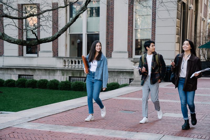 Students walking across a university campus during a competitive summer research program