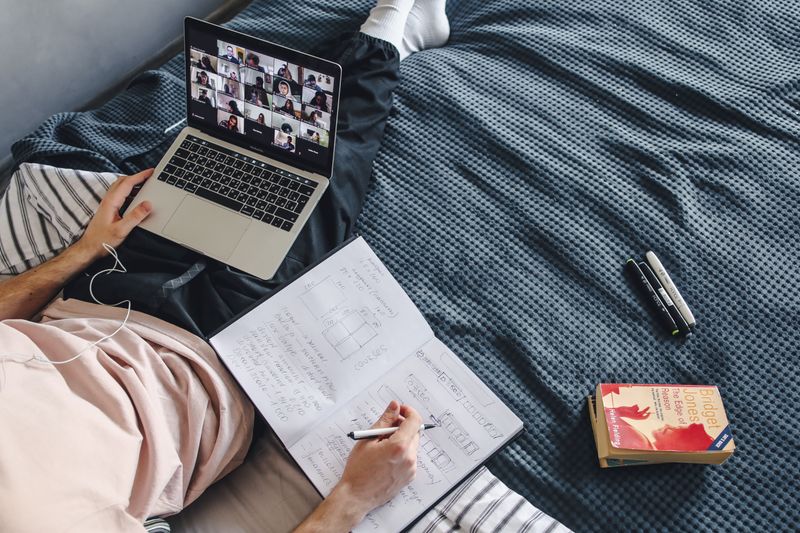 Student taking notes during an online precollege class