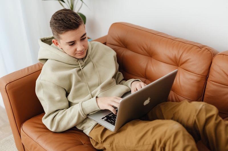 Student researching program applications on a laptop at home