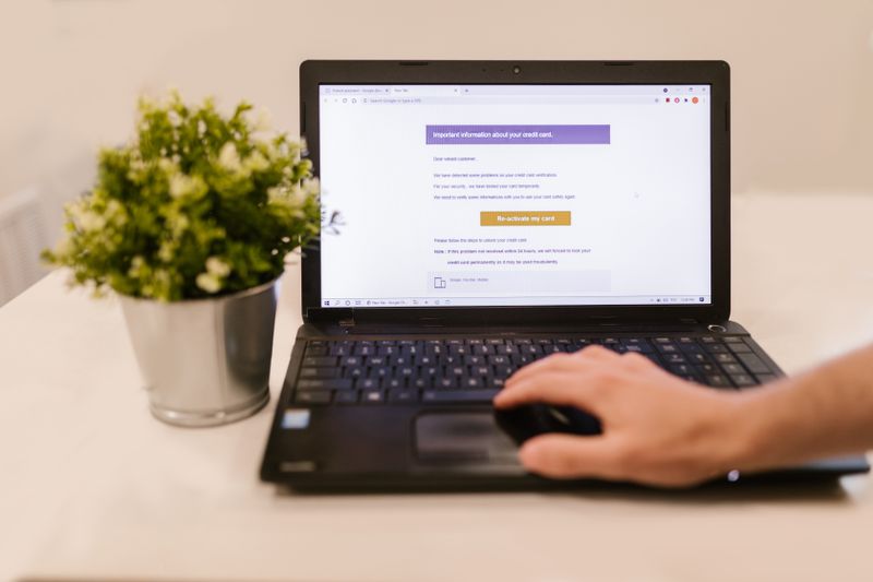 Hand submitting a completed application form on a laptop