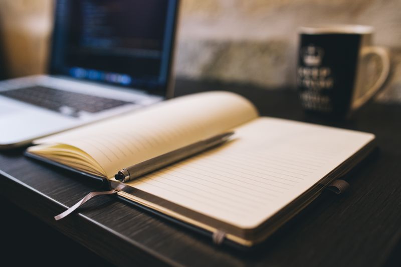 Notebook and laptop on a desk for planning a science fair project idea