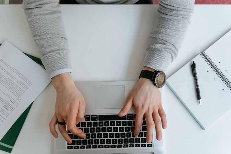 Student typing an ISEF research plan example on a laptop