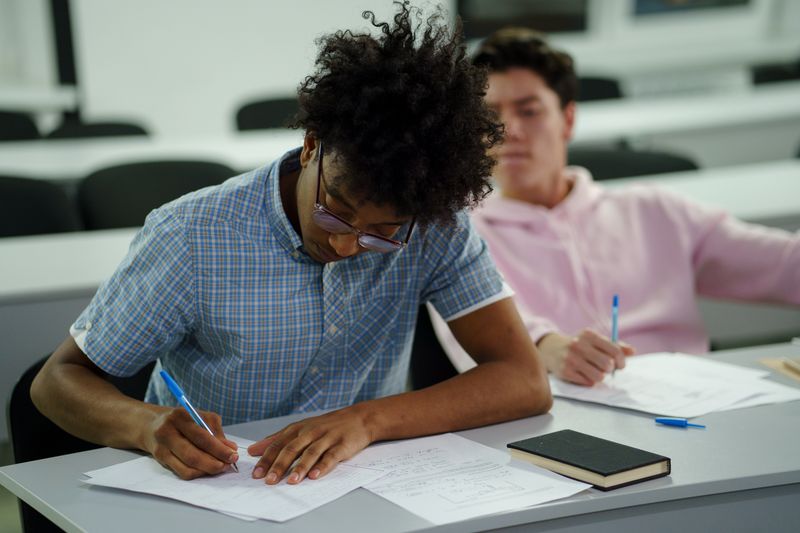 Students writing what goes in an ISEF research plan in class