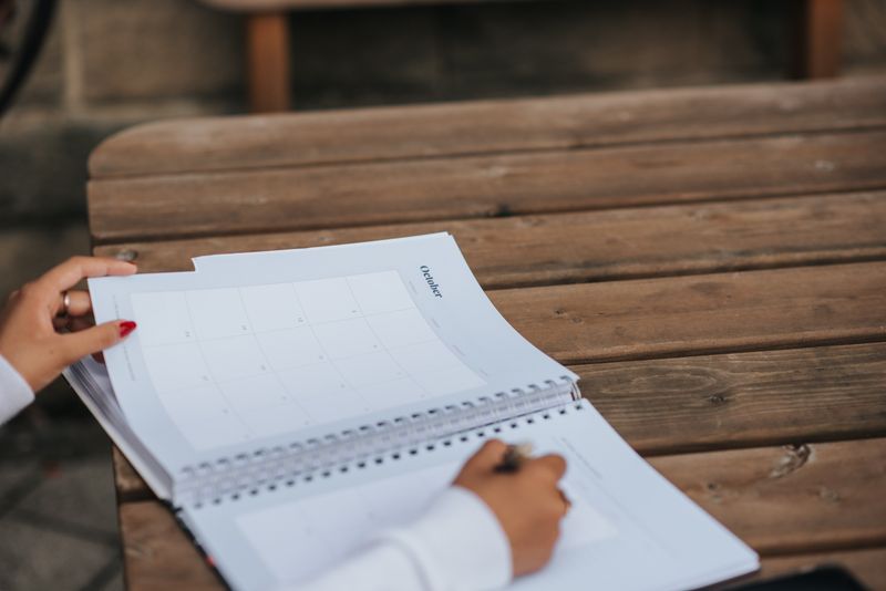 Student planning a college application timeline in a notebook