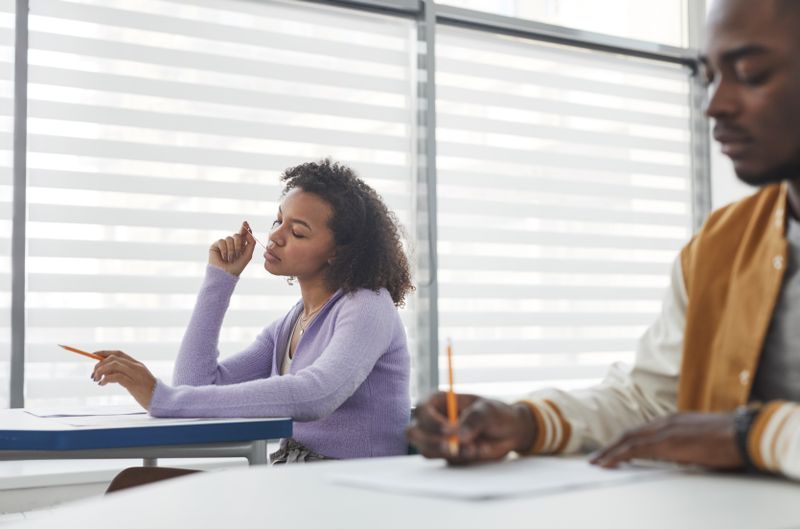 Student thinking through possible Ivy League essays topics at a desk