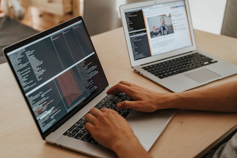 Hands typing code on laptops representing NASA OSTEM internship eligibility research