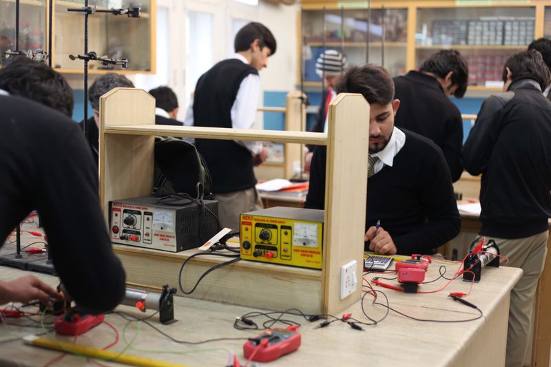 Students working with electronics equipment on a physical science project