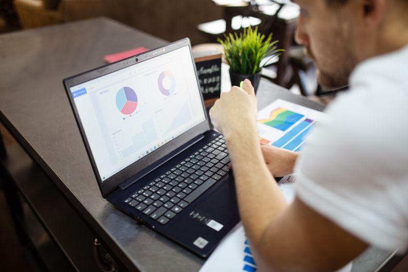 Laptop screen showing pie charts and bar graphs for a research results section