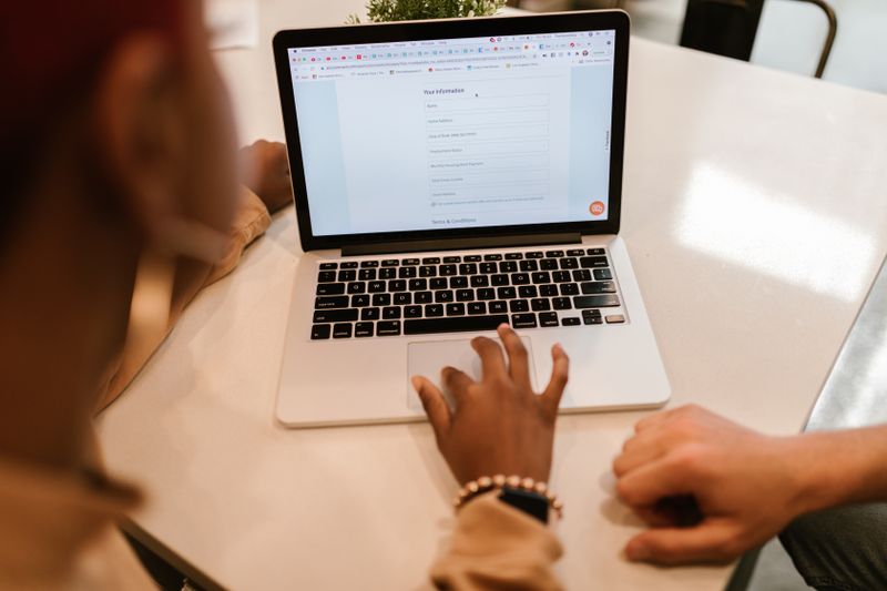 Students filling out a college application on a laptop before the regular decision deadline