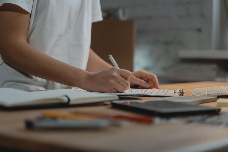 Student writing at a desk while planning around a rolling admission college deadline