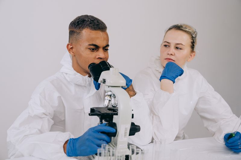 Students examining a microscope in a lab representing RSI eligibility for research-focused applicants