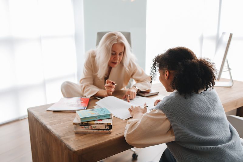 Student and college counselor reviewing application materials together