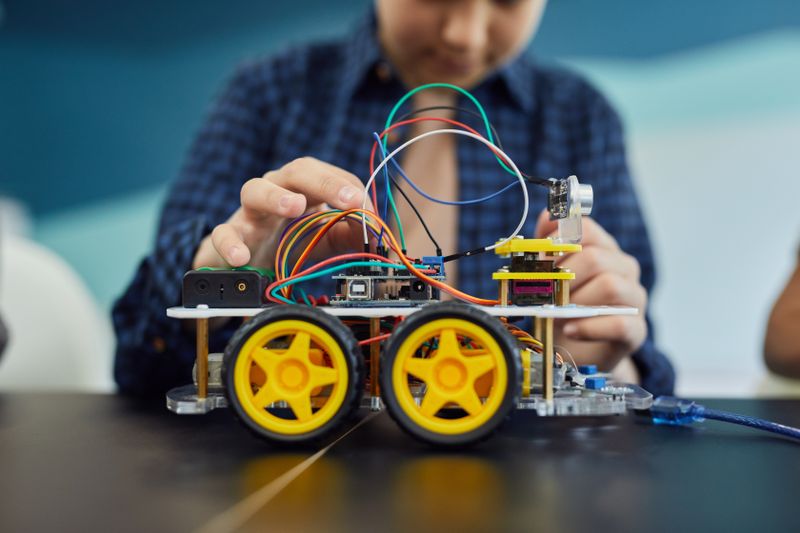 Hands wiring a circuit board for a Science Olympiad build event
