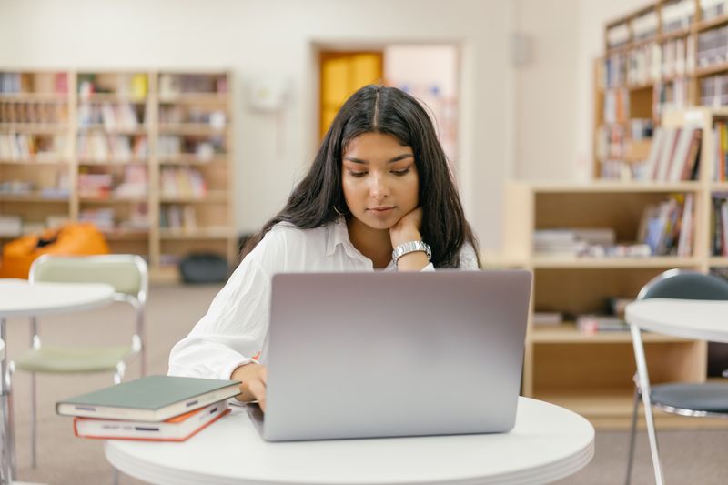 Student researching program cost and financial aid on a laptop