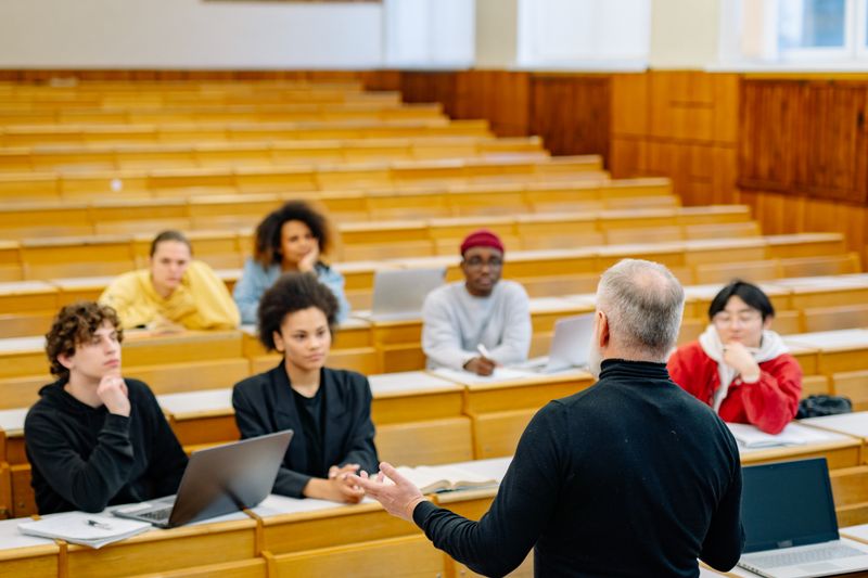 Instructor leading a college classroom discussion with high school students