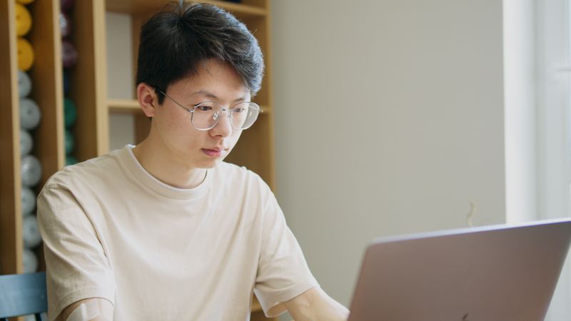 High school student preparing an internship application on a laptop at home