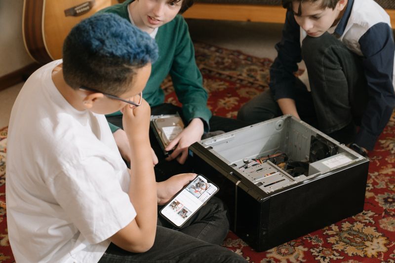 Students examining an open desktop computer tower as part of an IT internship search